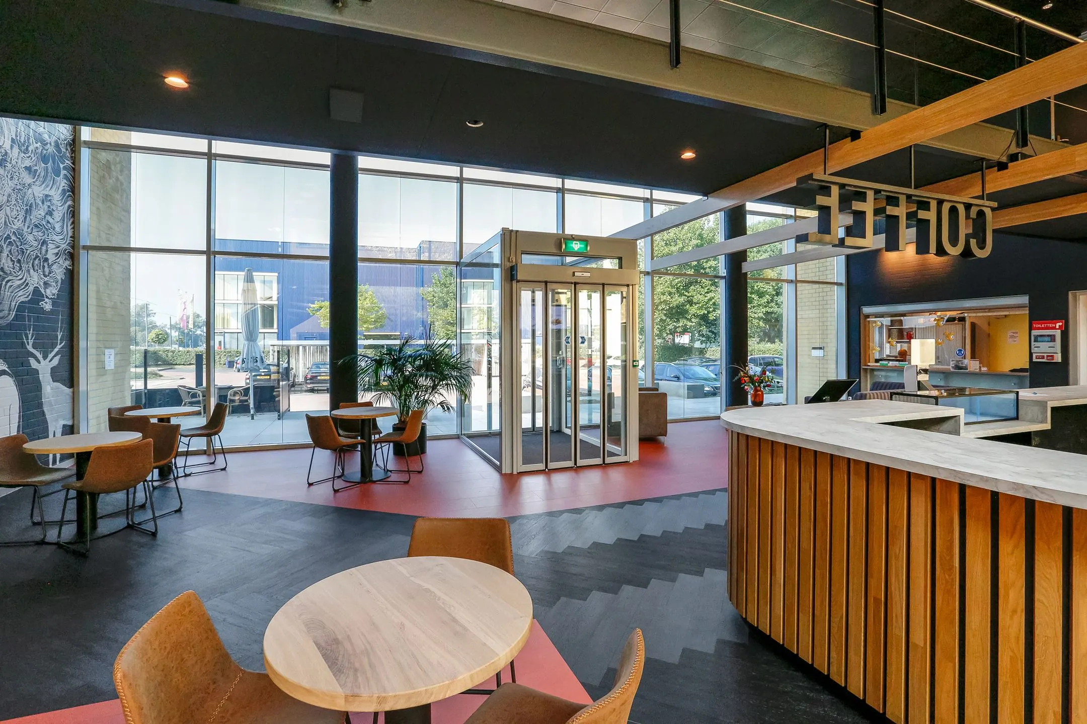 Moderne entreehal met zitgedeelte en koffiebalie in kantoorpand Meander 251 in Arnhem.