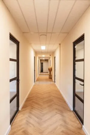 Licht en modern kantoorinterieur met een houten vloer en glazen kantoordeuren in Mercurion 24, Zevenaar.