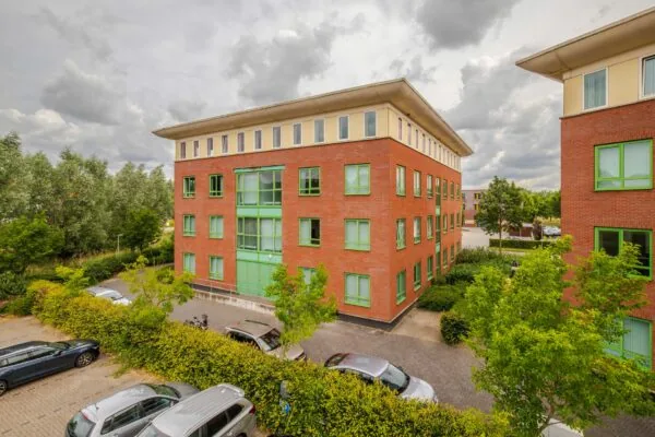 Buitenaanzicht van het kantoorgebouw Mercurion 24 in Zevenaar met rode bakstenen en groene kozijnen.