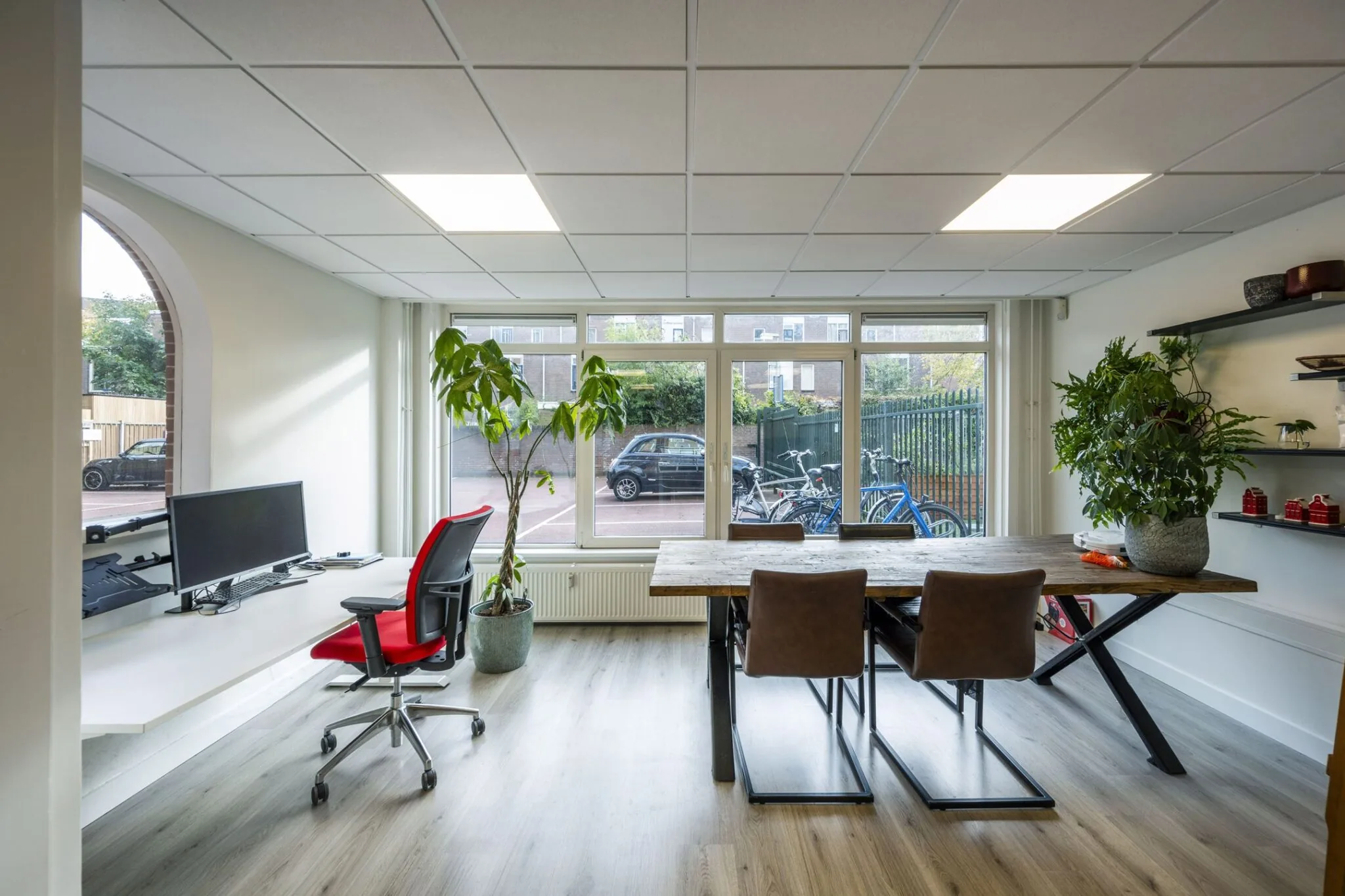 Moderne kantoorruimte aan de Nieuwe Gracht 45-47 in Haarlem met groot raam, vergadertafel, werkplek en veel daglicht.