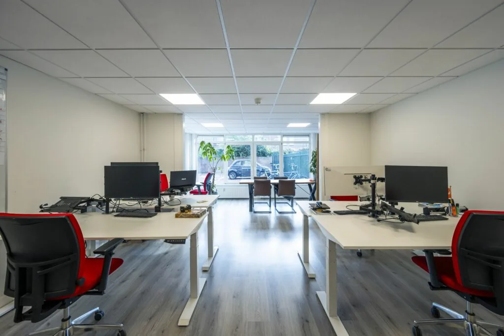 Moderne kantoorruimte aan de Nieuwe Gracht 45-47 in Haarlem met werkplekken, bureaustoelen en grote ramen.