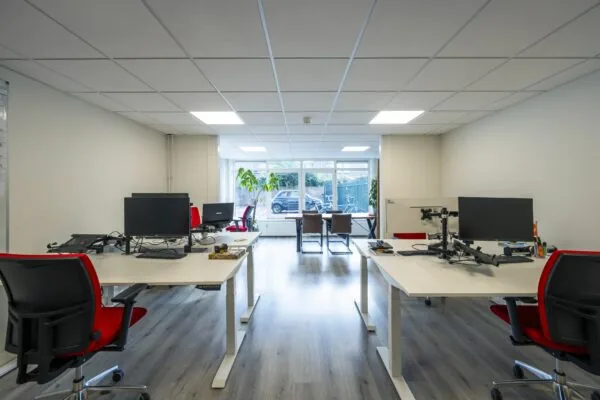Moderne kantoorruimte aan de Nieuwe Gracht 45-47 in Haarlem met werkplekken, bureaustoelen en grote ramen.