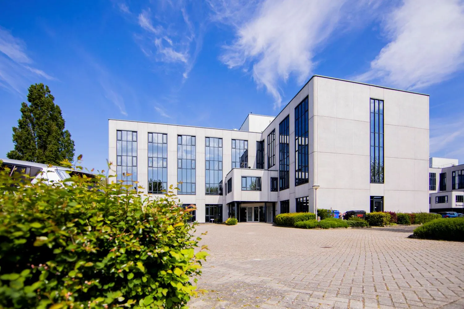 Modern kantoorgebouw aan de Pelmolenlaan 16 in Woerden met grote ramen en een ruime parkeerplaats.