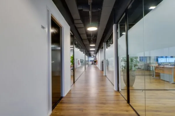 Moderne kantoorruimte aan de Pelmolenlaan 16 in Woerden met glazen wanden en houten vloer.