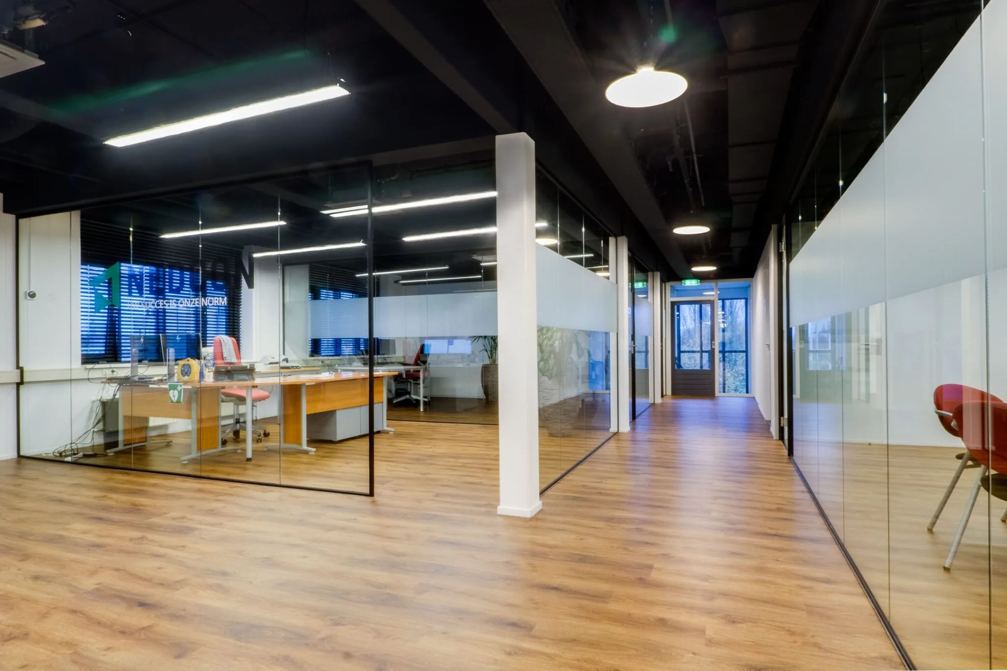 Moderne kantoorruimte met glazen wanden en houten vloer aan de Pelmolenlaan 16 in Woerden.