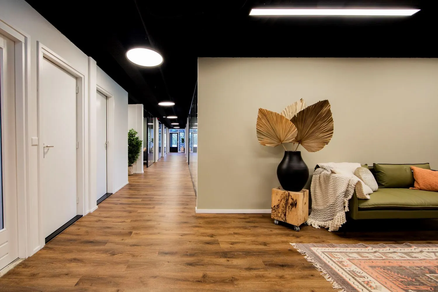 Moderne en sfeervolle kantoorruimte aan de Pelmolenlaan 16 in Woerden met houten vloer, strakke inrichting en comfortabele loungehoek.