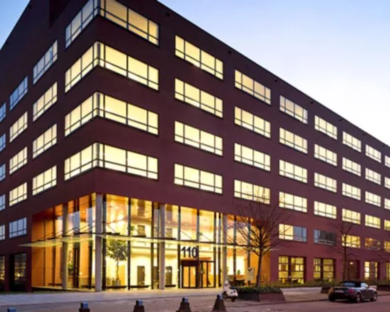 Modern kantoorgebouw aan de Teleportboulevard 110 in Amsterdam bij schemering.