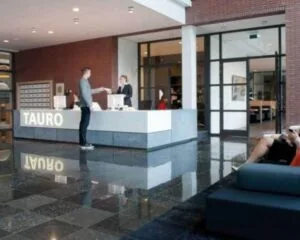 Moderne ontvangstruimte met receptiebalie van TAURO in kantoorgebouw aan de Teleportboulevard 110 in Amsterdam.