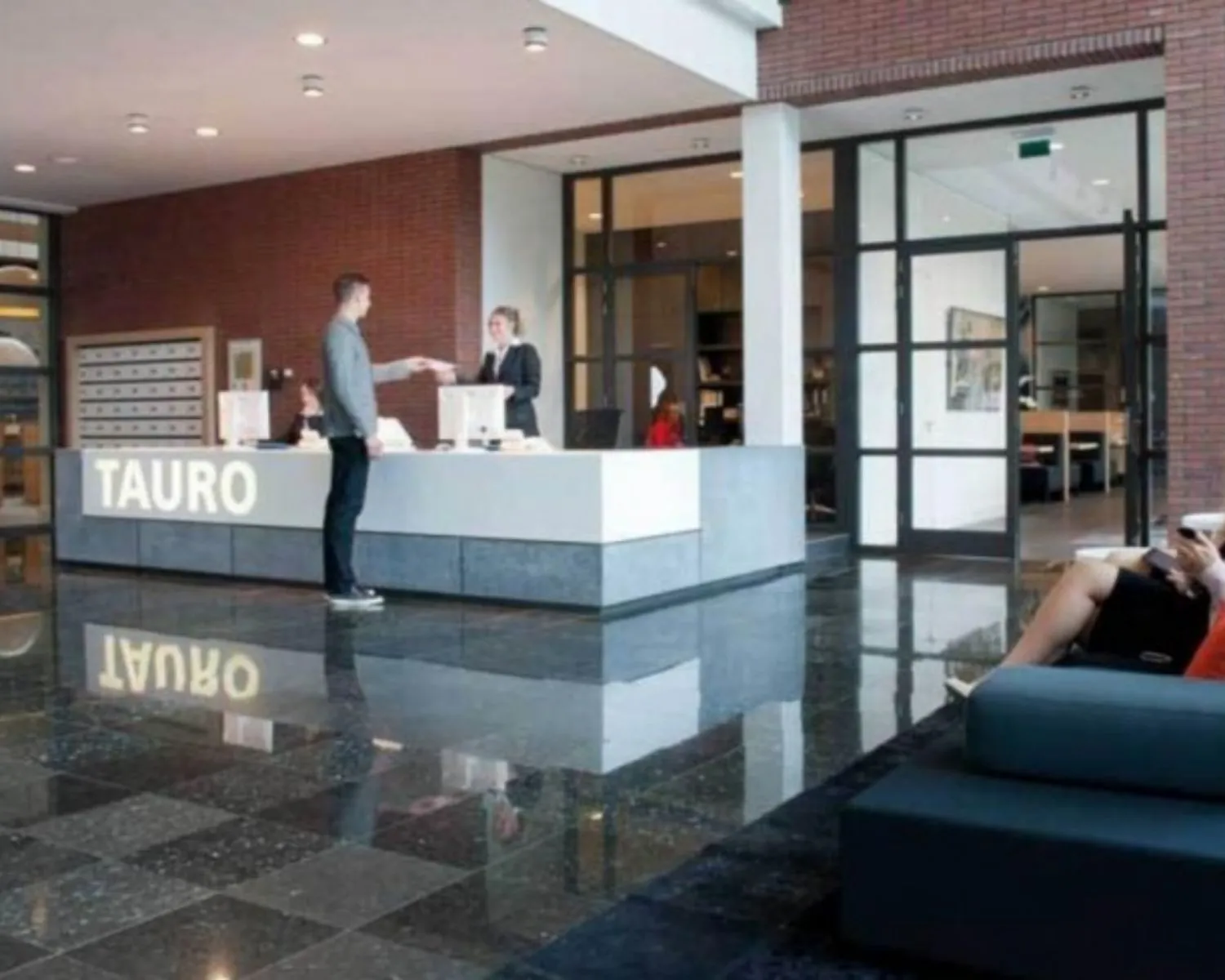 Moderne ontvangstruimte met receptiebalie van TAURO in kantoorgebouw aan de Teleportboulevard 110 in Amsterdam.