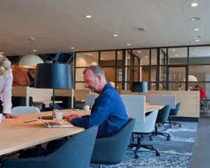 Moderne kantoorruimte aan de Teleportboulevard 110 in Amsterdam met werkplekken en mensen aan het werk.