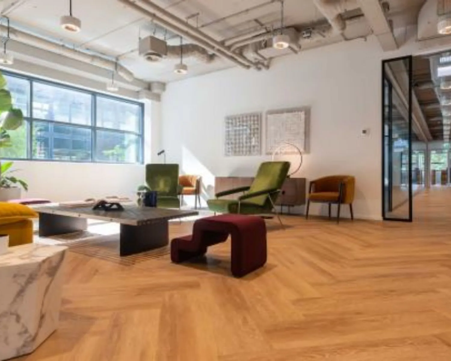 Moderne en sfeervolle kantoorlounge met designmeubels aan de Teleportboulevard 110 in Amsterdam.