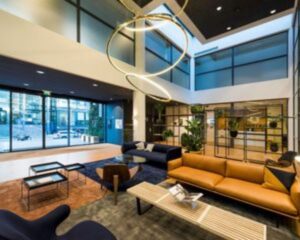 Moderne en stijlvolle kantoorlobby aan de Teleportboulevard 110 in Amsterdam met zitgedeelte, grote ramen en designverlichting.