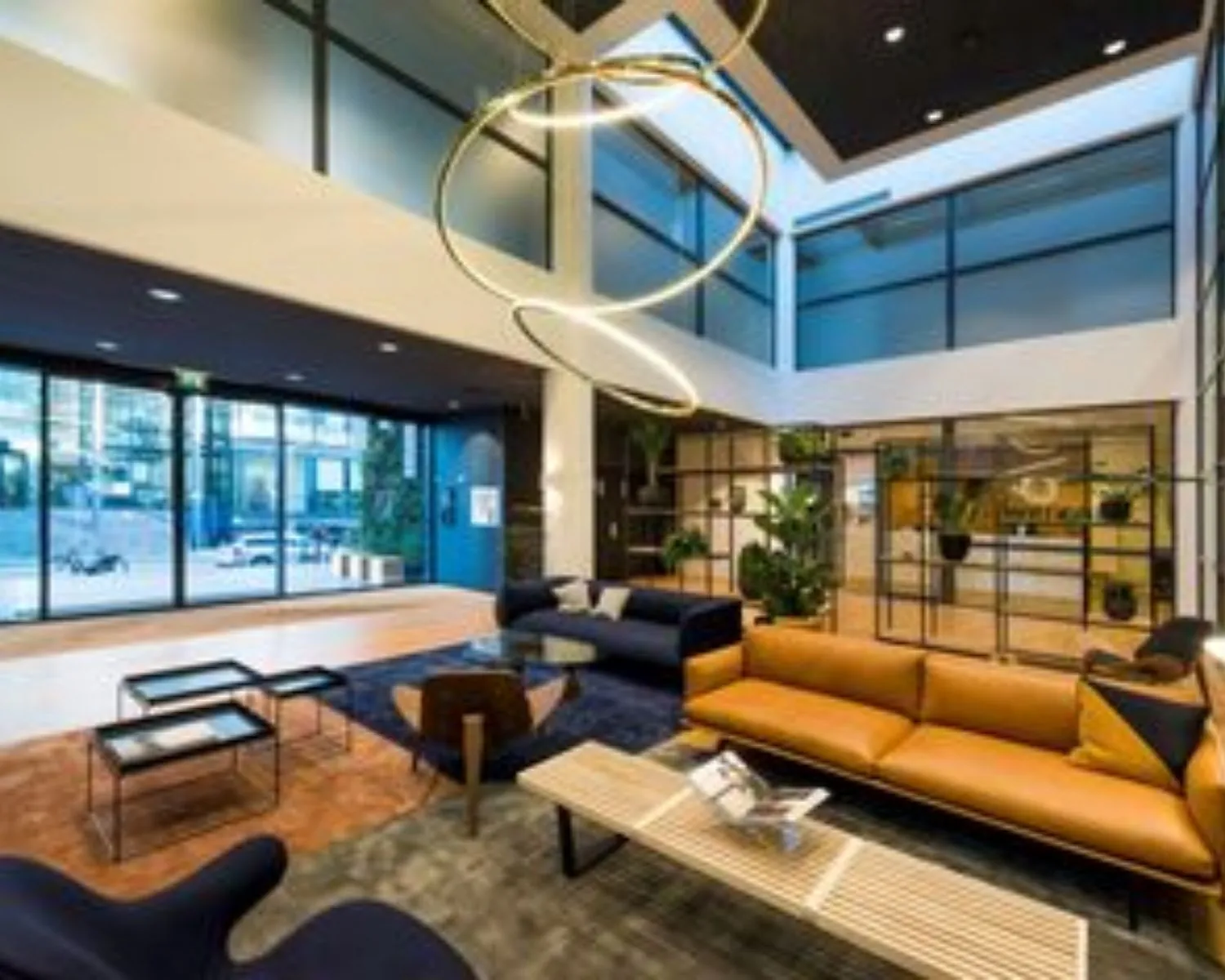 Moderne en stijlvolle kantoorlobby aan de Teleportboulevard 110 in Amsterdam met zitgedeelte, grote ramen en designverlichting.