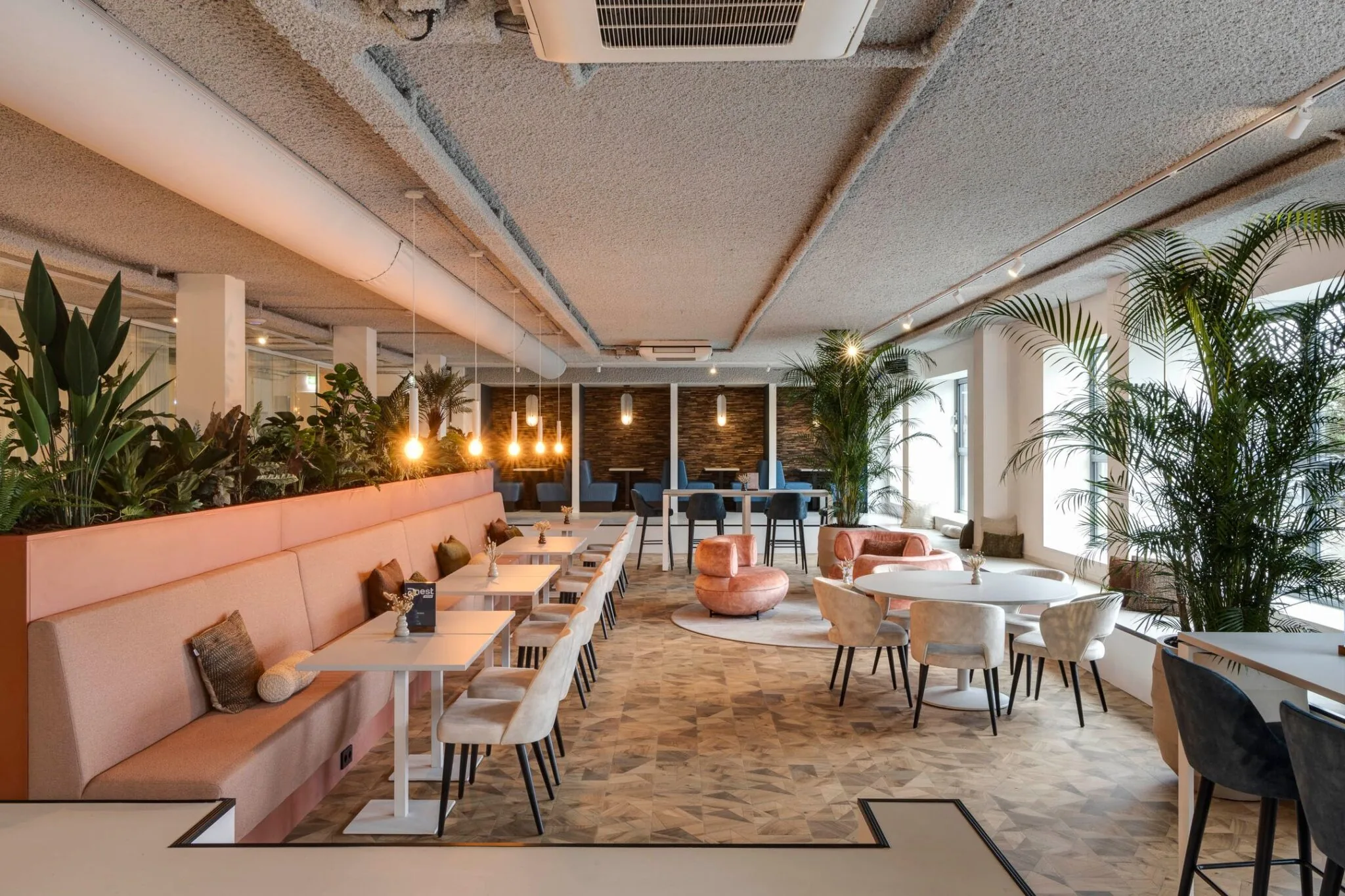 Moderne en sfeervolle kantoorruimte aan de Vanadiumweg 11 in Amersfoort met strakke zitjes, warme verlichting en veel groen.