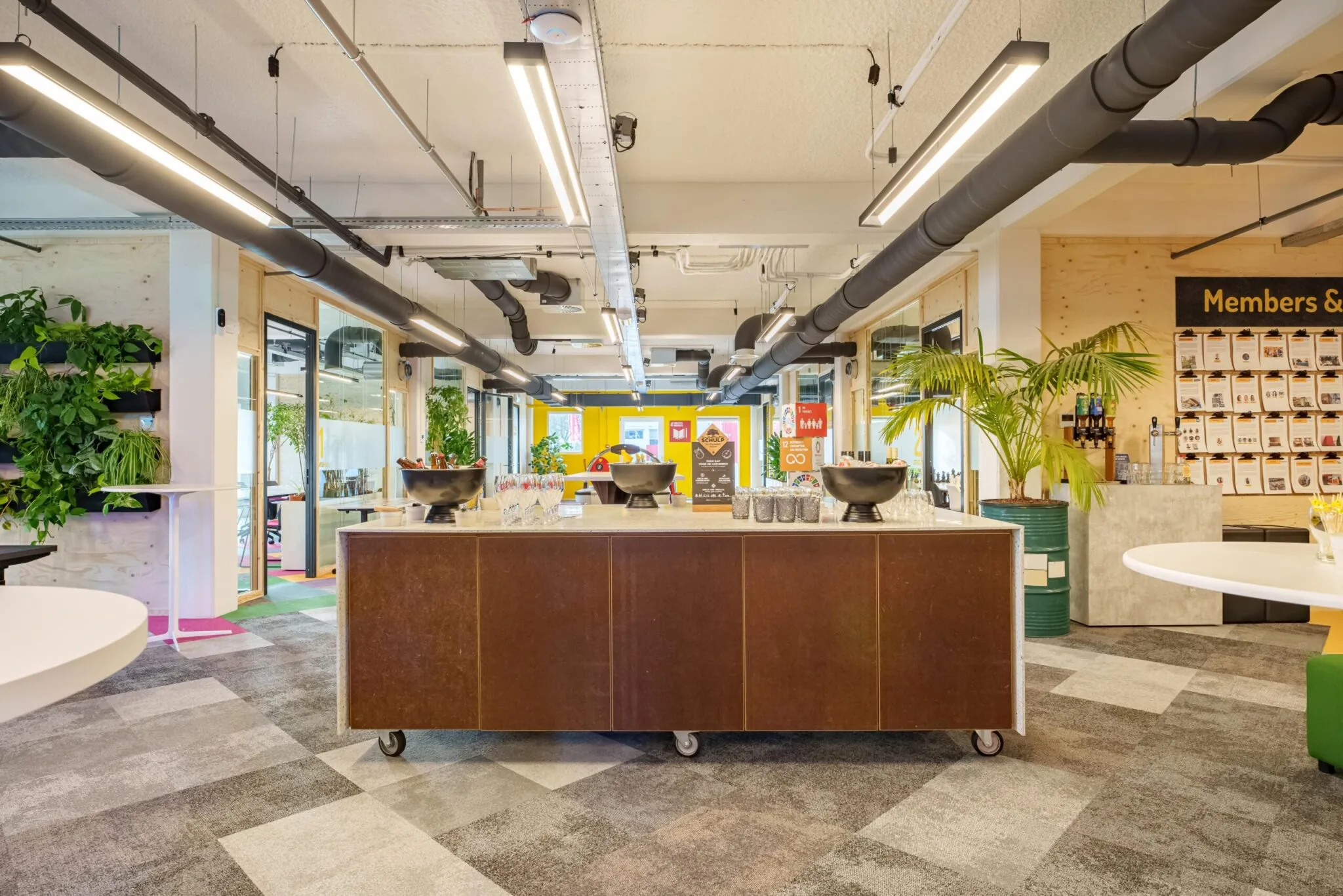 Moderne en kleurrijke kantoorruimte met planten, verlichting, en een centrale bar bij Willem Fenengastraat 15 in Amsterdam.