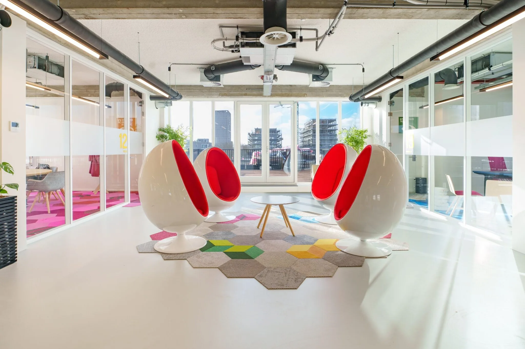 Moderne en lichte kantoorruimte aan de Willem Fenengastraat 2 in Amsterdam met designstoelen en uitzicht op de stad.