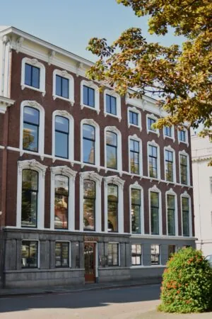 Voorgevel van een klassiek kantoorpand aan de Zeestraat 70 in Den Haag met grote ramen en het bord "CA Avenue" boven de ingang.