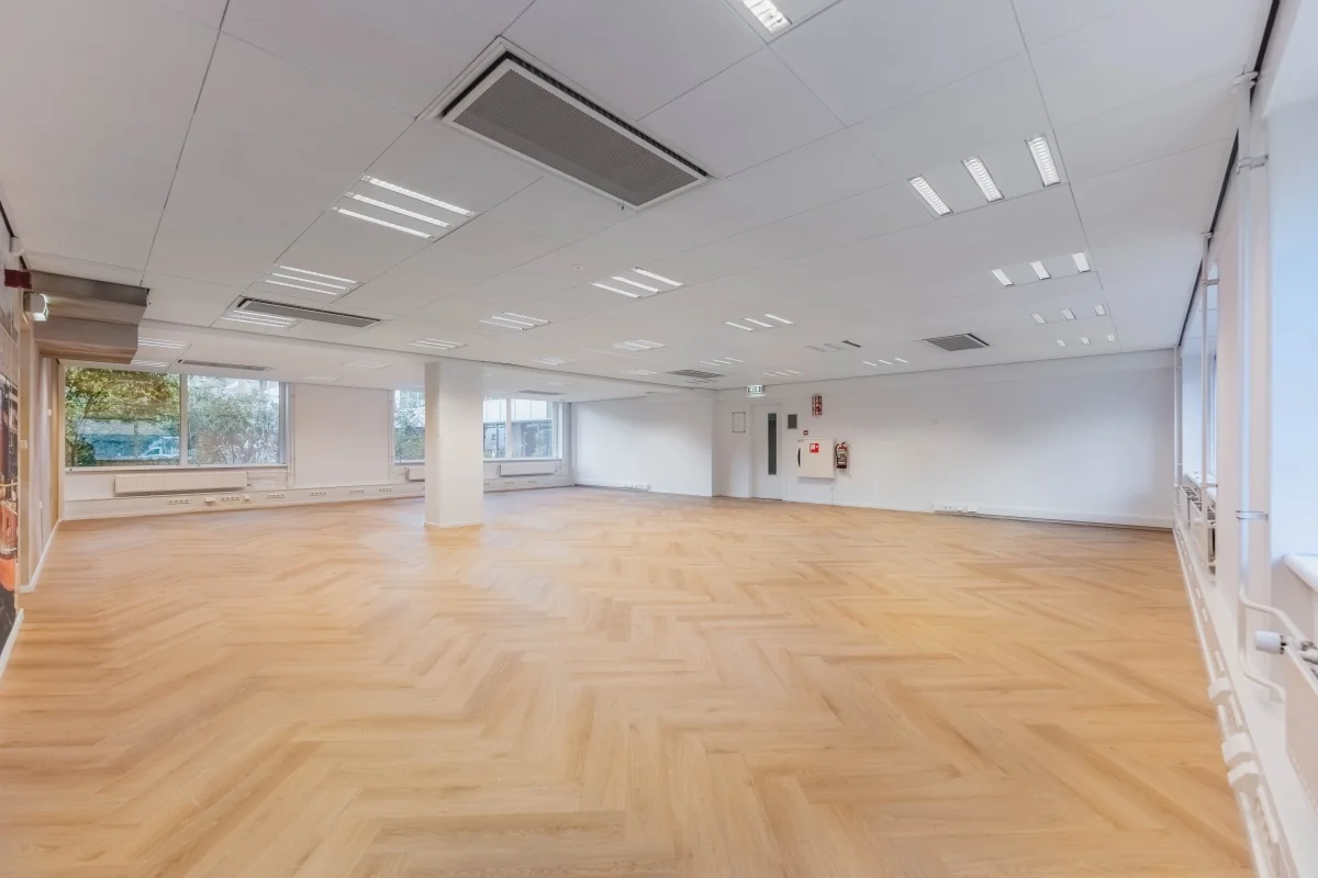 Lichte, lege kantooruimte met visgraat houten vloer aan de Weesperstraat 107-11.