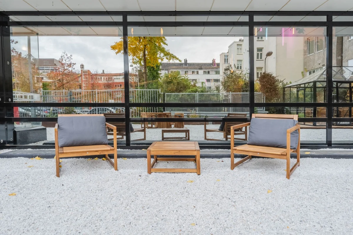 Houten loungeset met twee stoelen en een tafel op het terras van kantoorpand Weesperstraat 107.