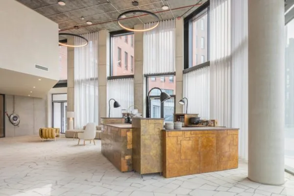 Moderne, lichte kantoorlobby aan de HJE Wenckebachweg 230 in Amsterdam met hoge ramen, industriële details en een stijlvolle ontvangstbalie.