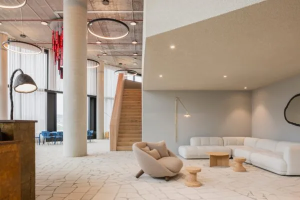 Moderne en stijlvolle kantoorlounge aan de H.J.E. Wenckebachweg 230 in Amsterdam met designmeubilair, houten trap en grote ramen.