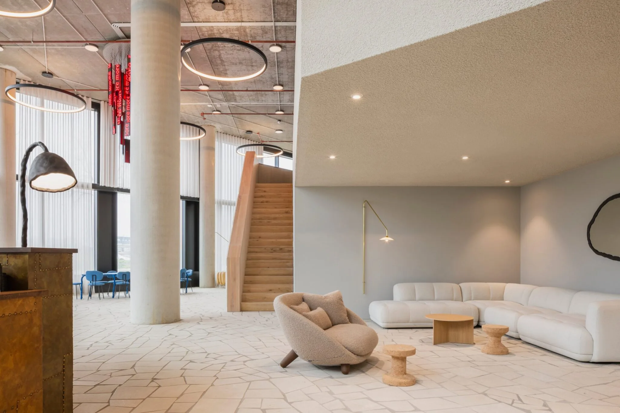 Moderne en stijlvolle kantoorlounge aan de H.J.E. Wenckebachweg 230 in Amsterdam met designmeubilair, houten trap en grote ramen.