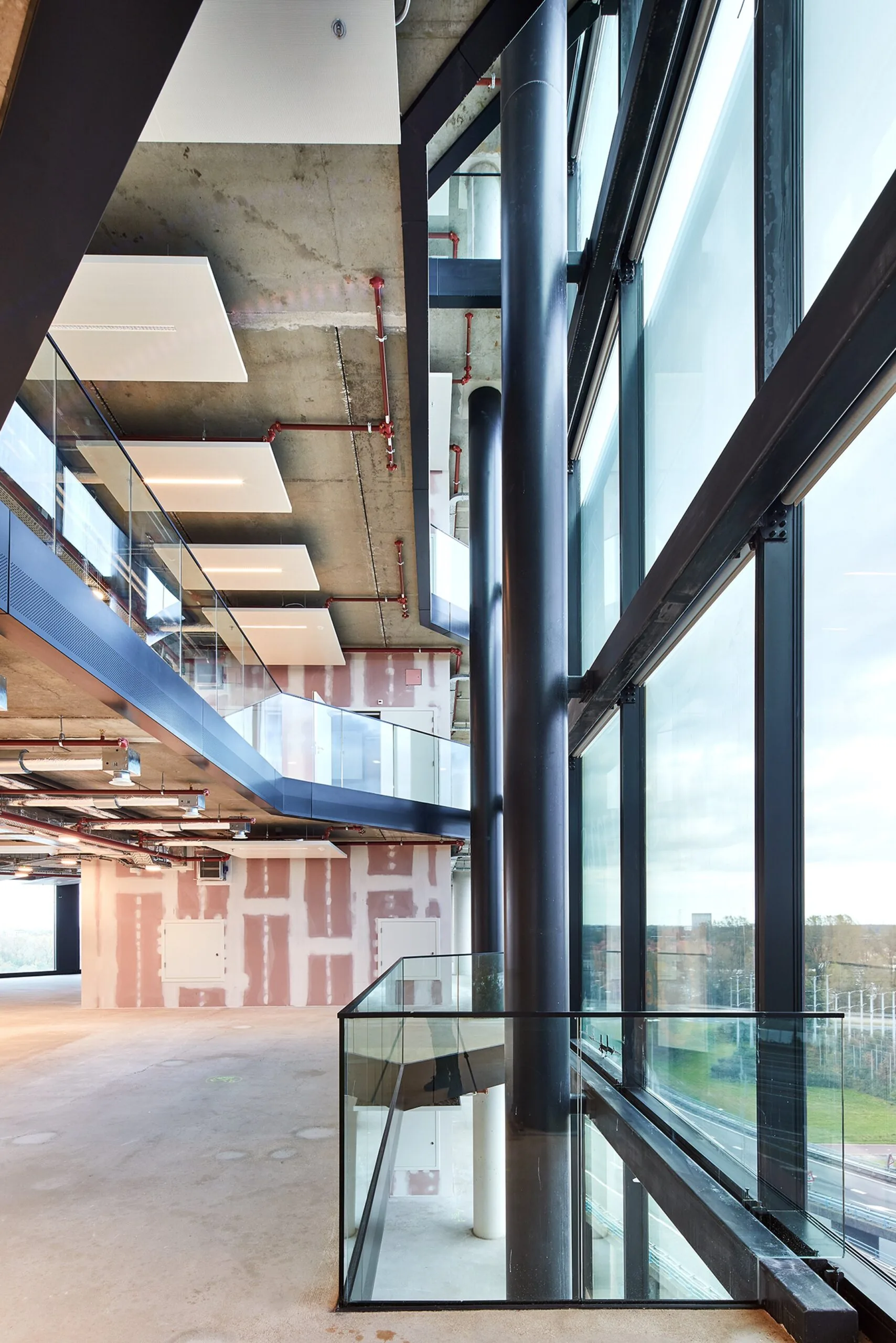Ruime, industriële kantooretage met betonnen plafond, glazen balustrades en grote ramen aan de H.J.E. Wenckebachweg 230 in Amsterdam.