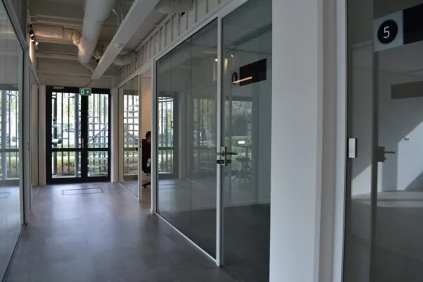 Moderne gang met glazen kantoorruimtes in bedrijfsverzamelgebouw aan de Keulenstraat 9 in Deventer.