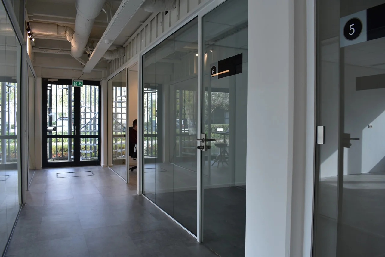 Moderne gang met glazen kantoorruimtes in bedrijfsverzamelgebouw aan de Keulenstraat 9 in Deventer.