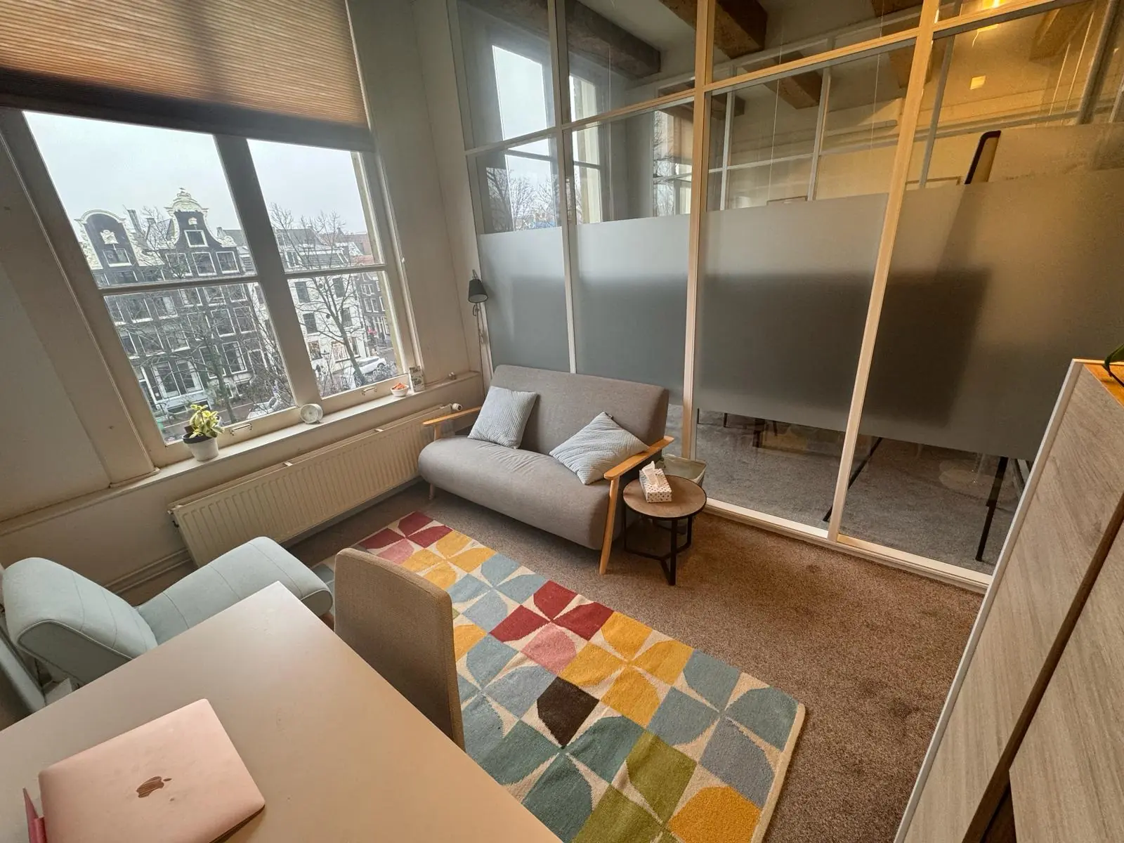 Kleine, sfeervolle werkruimte aan de Keizersgracht met uitzicht op Amsterdamse grachtenpanden.