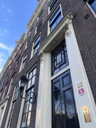 Voorgevel van het pand Keizersgracht 261 in Amsterdam met zwarte deur, klassieke geveldetails en huisnummerbordje.