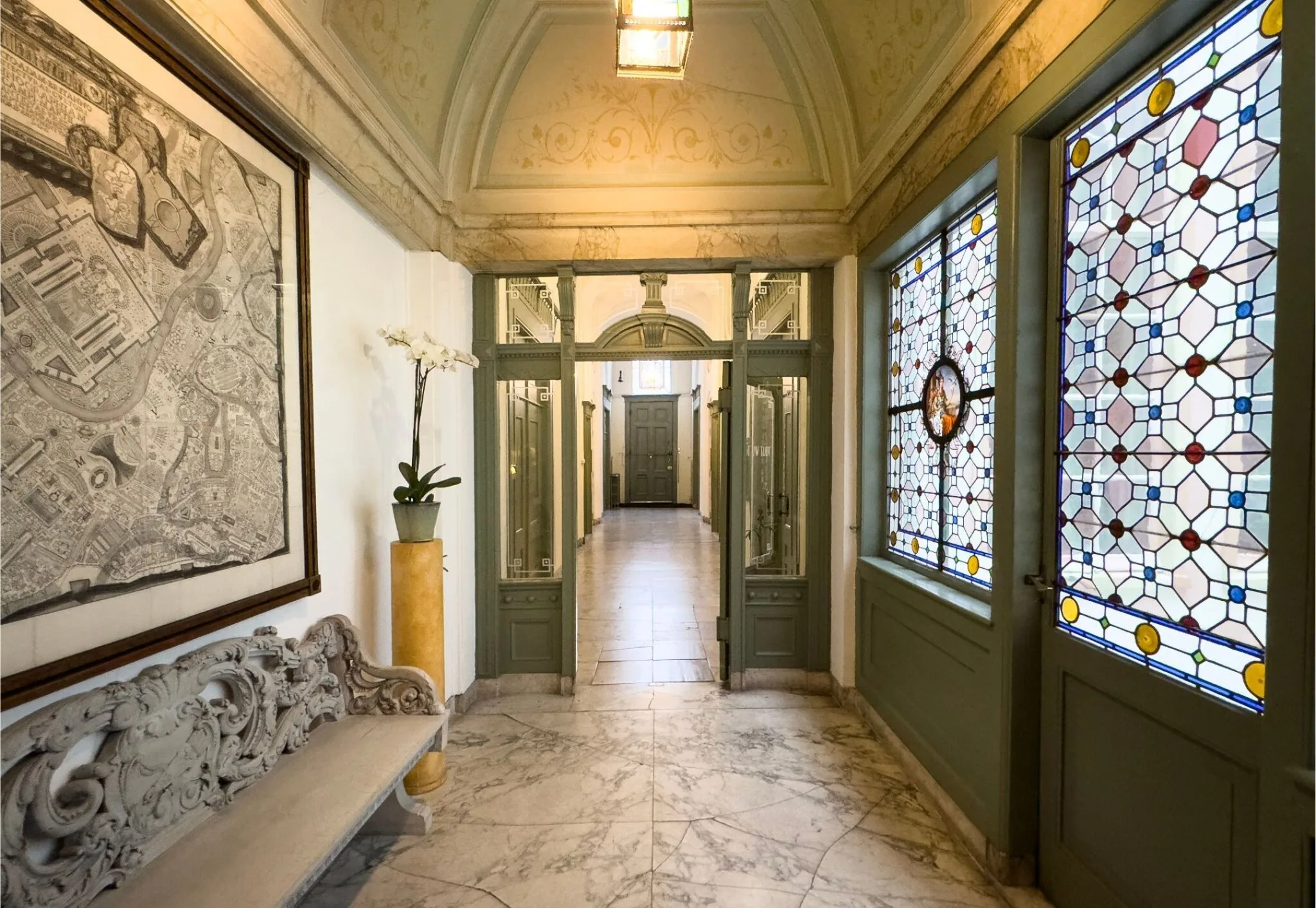 Monumentaal interieur van Keizersgracht 261 met marmeren vloer, glas-in-loodramen en klassieke details.