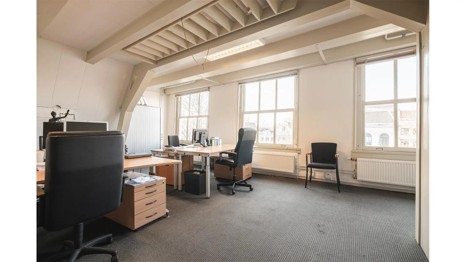 Licht en ruim kantoor met meerdere bureaus en stoelen op Keizersgracht 261.