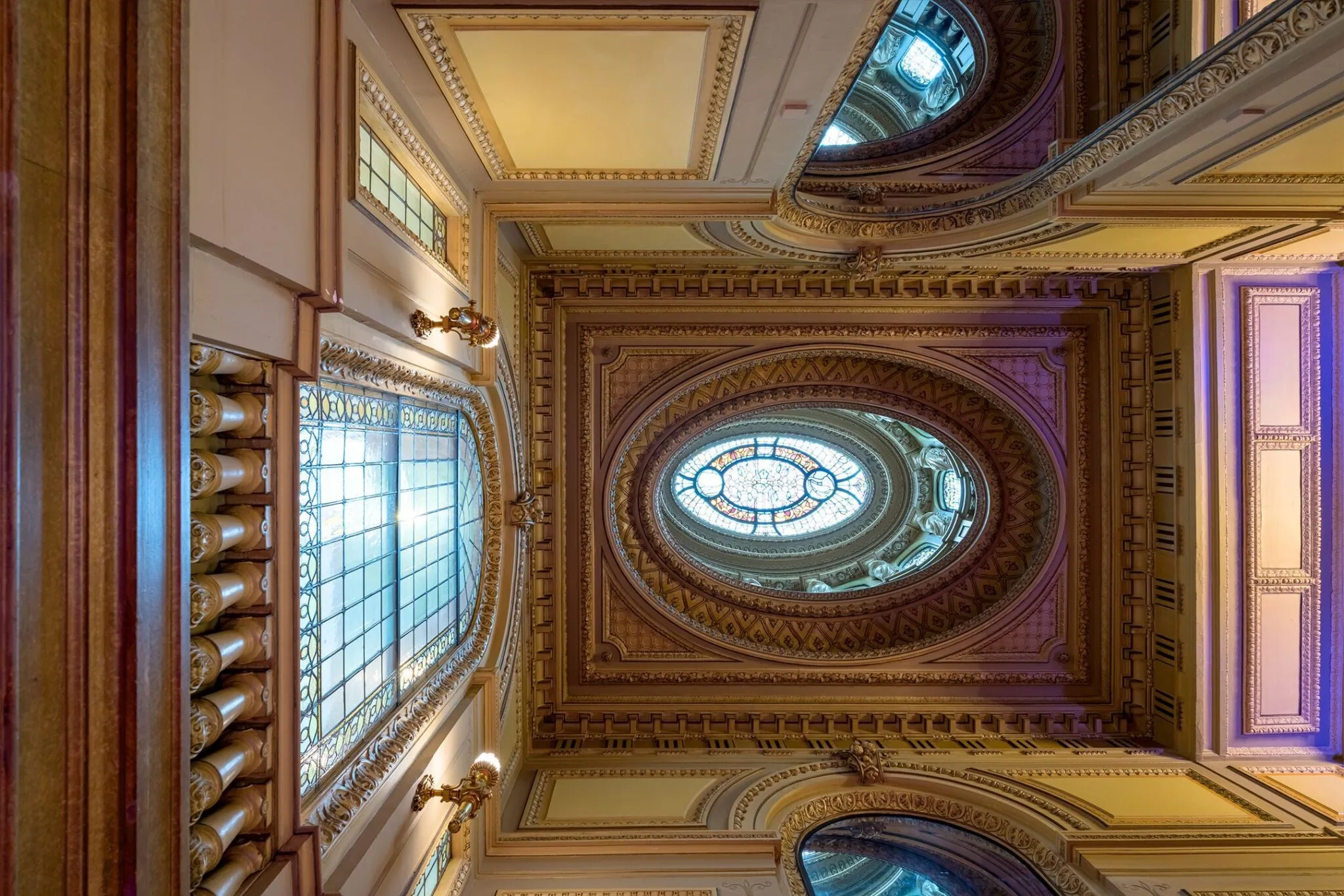 Plafond met rijk gedecoreerde lijsten en glas-in-loodramen in het historische pand aan de Keizersgracht 452.