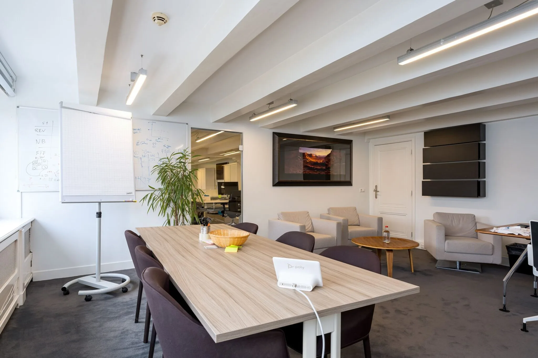 Vergaderruimte in Keizersgracht 452 met houten tafel, flip-over, zithoek en whiteboards.