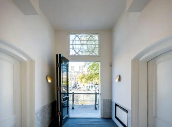 Doorkijk vanuit de hal van Keizersgracht 572 naar buiten met zicht op de gracht en grachtenpanden.