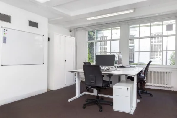 Licht en modern kantoorinterieur met bureaus, bureaustoelen en grote ramen aan de Keizersgracht 64.