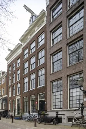 Voorgevel van het historische grachtenpand Keizersgracht 97 in Amsterdam met bakstenen gevel, grote ramen en geparkeerde fietsen.