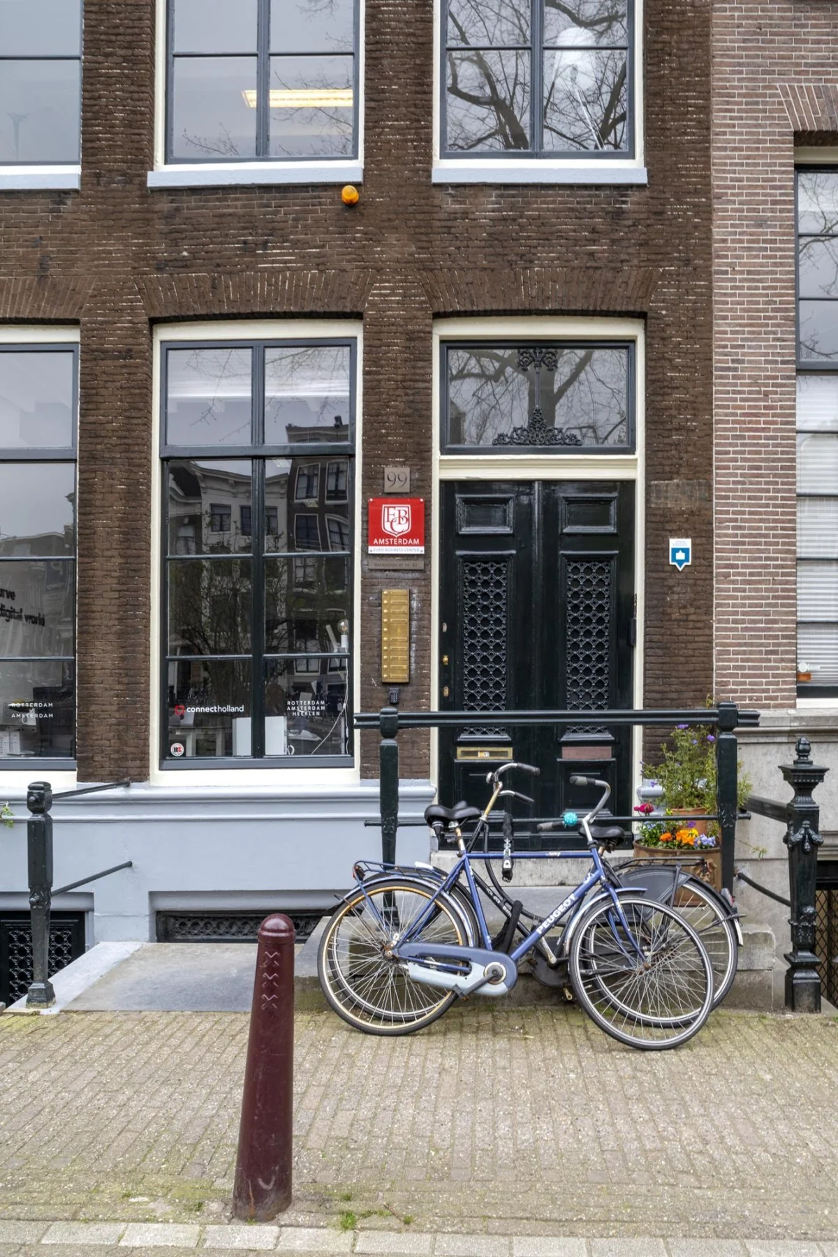 Twee fietsen staan geparkeerd voor de ingang van het pand aan de Keizersgracht 97 in Amsterdam.