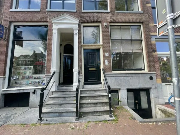 Voorgevel van Kloveniersburgwal 58 met twee entrees en een naastgelegen boekwinkel.