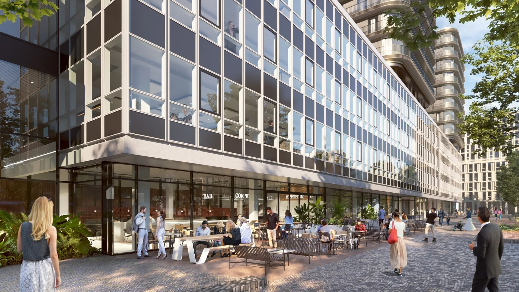 Moderne gevel van het gebouw aan Koningin Wilhelminaplein 4 met een levendig terras en voorbijgangers op een zonnige dag.
