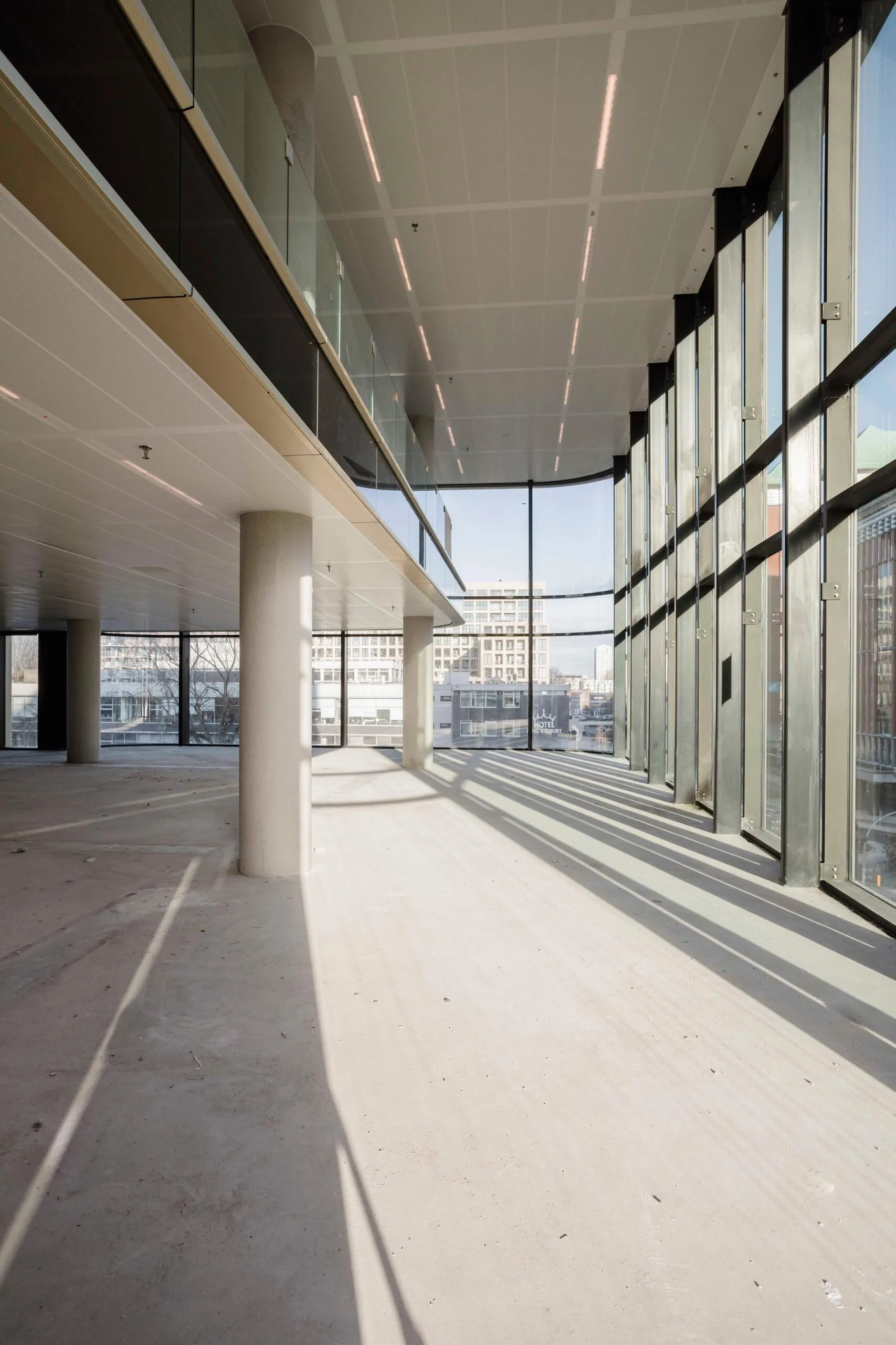 Lichte, lege kantoorruimte in Koninginne Wilhelminaplein 4 met hoge ramen en uitzicht op de stad.