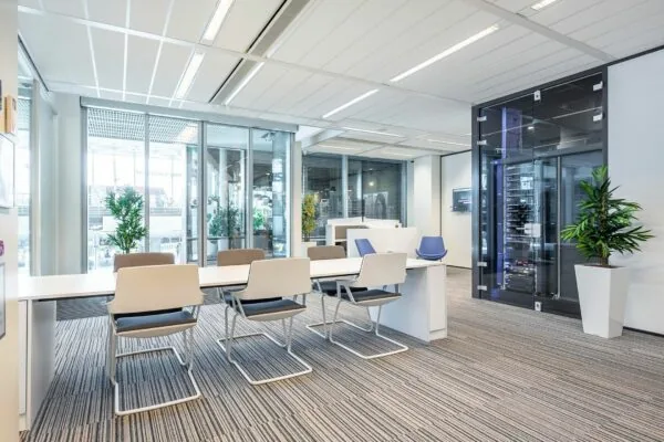 Moderne vergaderruimte met glazen wanden, strakke kantoormeubels en serverkast op Koningin Juliana Plein 10.