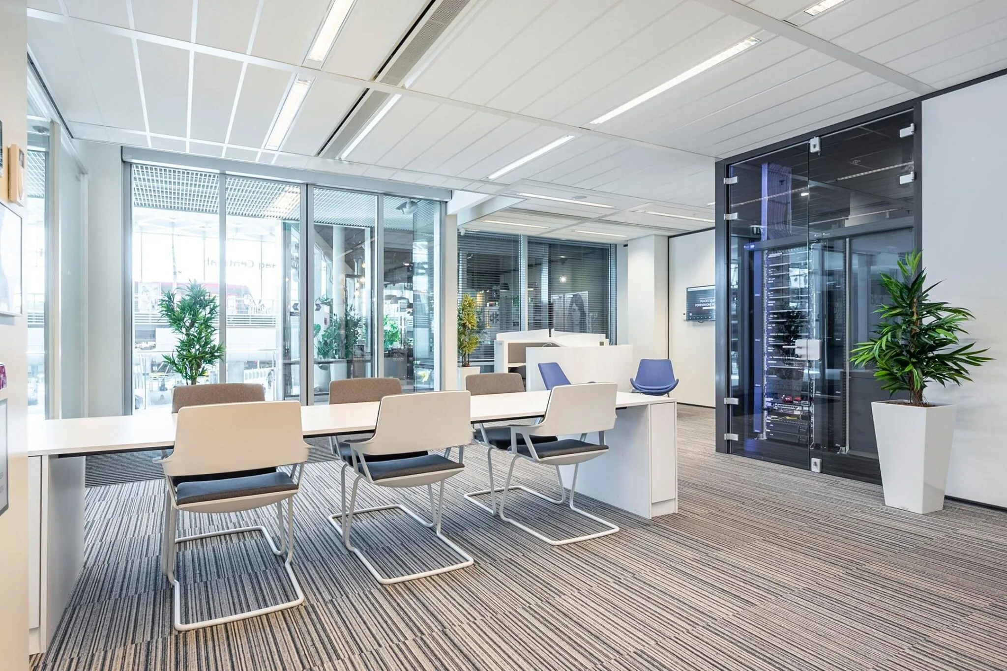 Moderne vergaderruimte met glazen wanden, strakke kantoormeubels en serverkast op Koningin Juliana Plein 10.