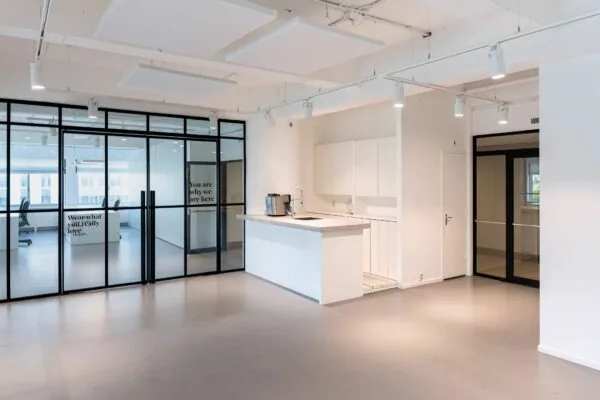 Moderne kantoorruimte aan het Koningin Wilhelminaplein met een open keuken en glazen vergaderruimtes.