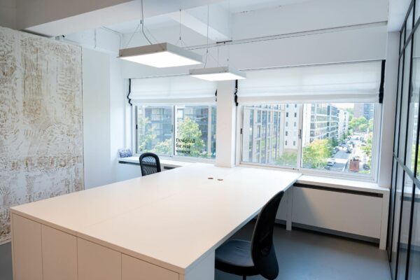 Modern kantoorinterieur aan het Koningin Wilhelminaplein 13 met grote ramen en uitzicht op een stedelijke straat.