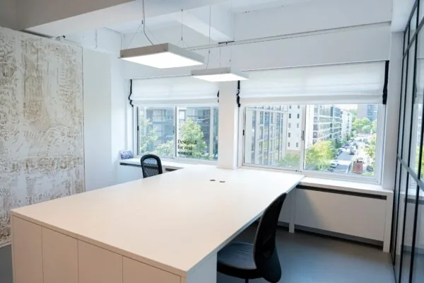 Modern kantoorinterieur aan het Koningin Wilhelminaplein 13 met grote ramen en uitzicht op een stedelijke straat.