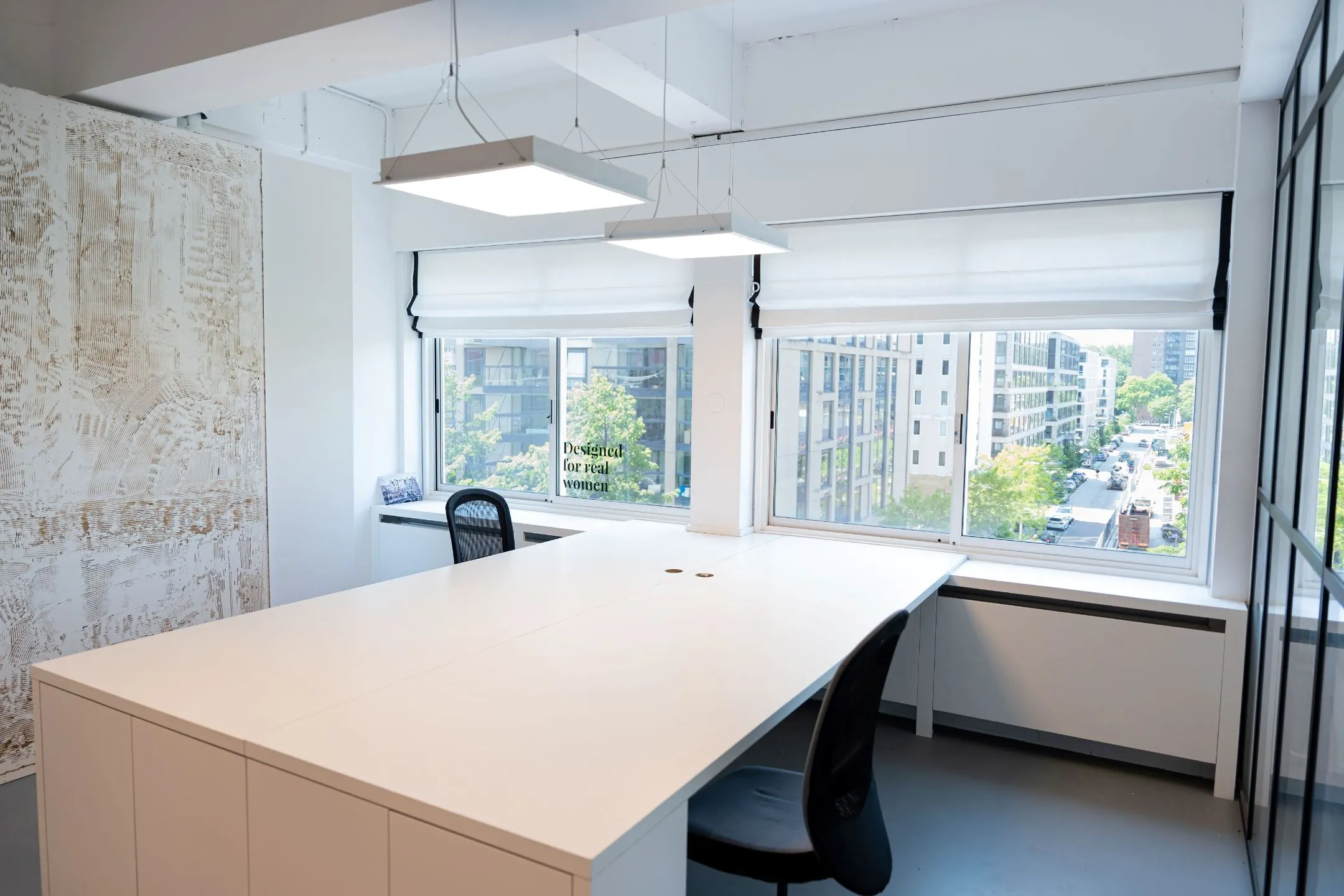 Modern kantoorinterieur aan het Koningin Wilhelminaplein 13 met grote ramen en uitzicht op een stedelijke straat.