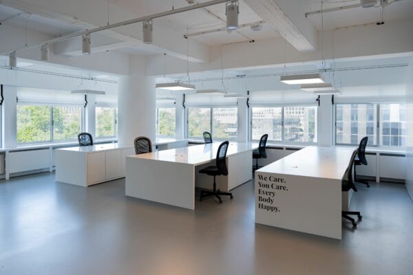 Licht en modern kantoorinterieur aan het Koningin Wilhelminaplein met grote ramen en minimalistische werkplekken.