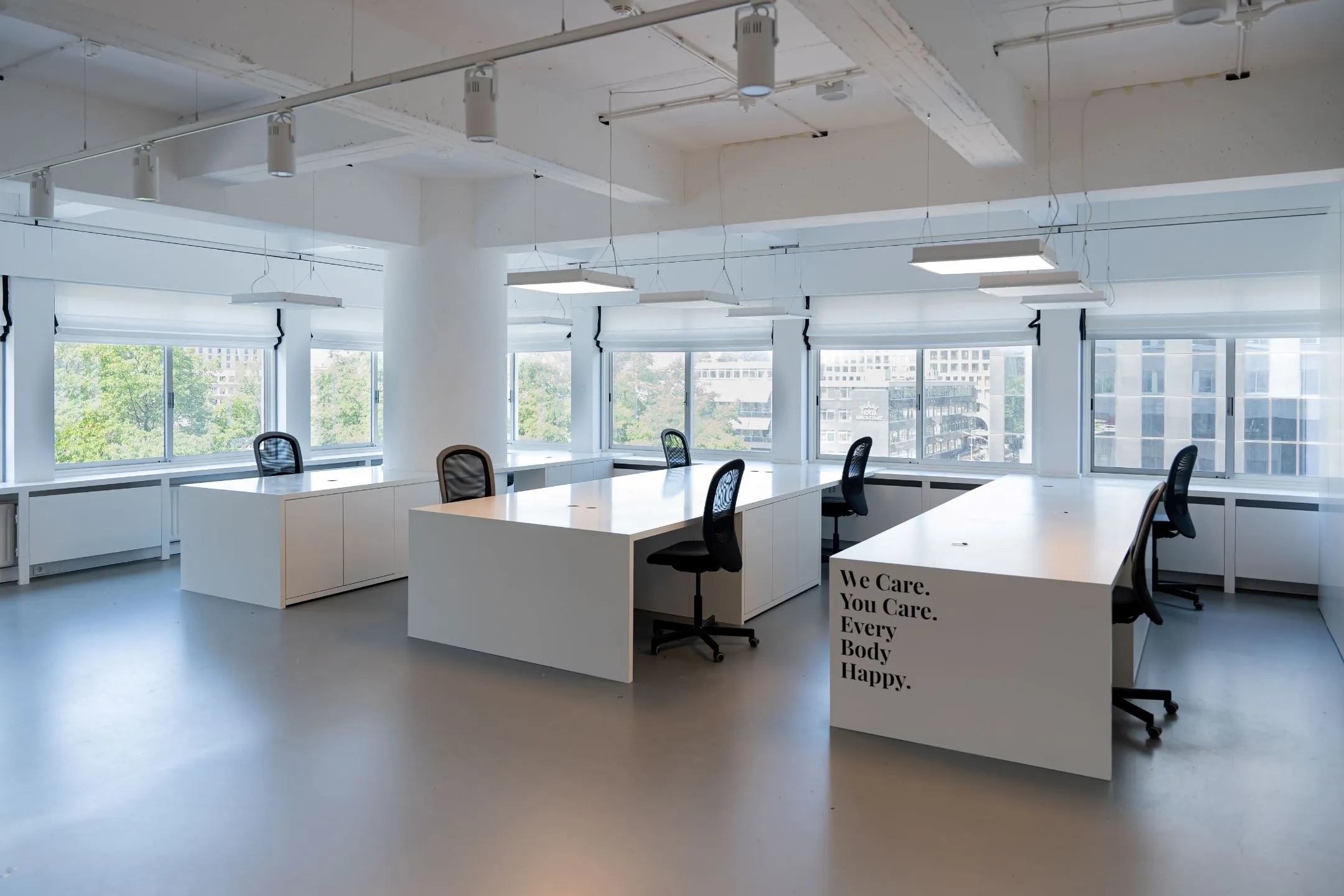 Licht en modern kantoorinterieur aan het Koningin Wilhelminaplein met grote ramen en minimalistische werkplekken.